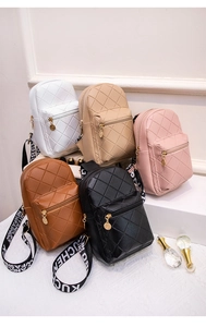 Détail de cinq mini sacs matelassés avec bandoulières contrastées en tissu logotypé