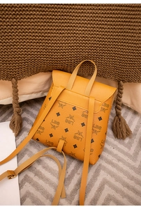 Dettaglio mini zaino monogramma giallo senape con spallacci regolabili e trama a grana fine