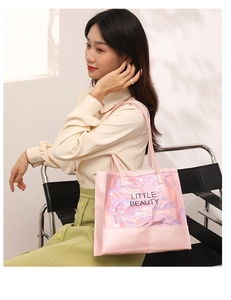 Pink tote bag detail with holographic Little Beauty logo panel shown on a model