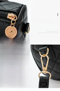 Detail of black quilted leather handbag with gold zipper and detachable metal hooks