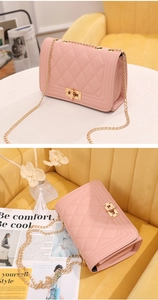Detail of pink quilted shoulder bag featuring gold chain strap and metal turn-lock closure