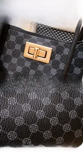 Macro shot of golden twist-lock hardware and textured clover print material on handbag