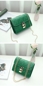 Close-up of green quilted faux leather crossbody bag with gold chain and twist lock