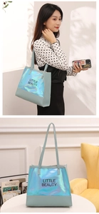 Close-up of mint green holographic tote bag with Little Beauty printed text and thin straps