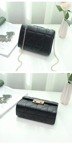 Detail of black quilted leather crossbody bag with gold chain strap and metal clasp