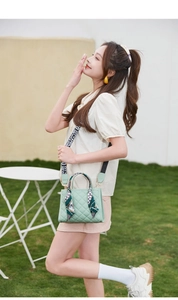 Mint green quilted crossbody bag with silk scarf handle and printed wide strap outdoors