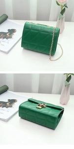 Close-up of forest green quilted leather bag with gold chain strap and square metal lock