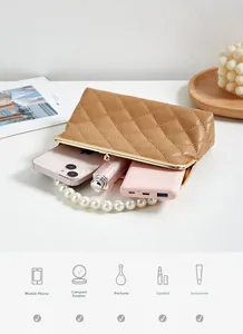Detailed interior of brown quilted leather bag with pearl handle showing storage capacity