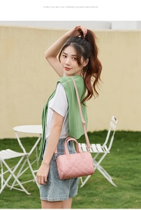 Close-up of pink quilted Boston handbag with gold hardware and adjustable strap
