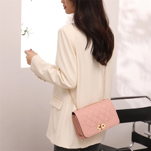 Pink quilted crossbody chain bag with gold hardware shown on female model outfit