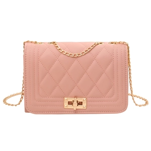 Pink quilted crossbody bag with gold chain strap and turn-lock closure on white background