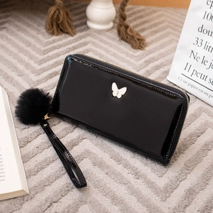 Glossy black patent leather long zipper wallet for women with butterfly emblem and fur ball
