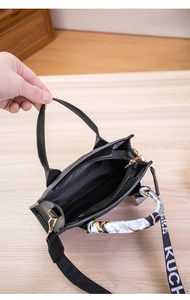 Detail view of the interior compartment and silk scarf handle of the black quilted handbag
