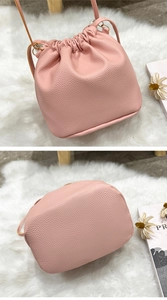 Macro detail of pink pebble texture leather and stitched base of the drawstring bucket bag