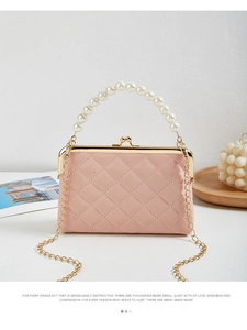 Close-up of pink quilted handbag with pearl top handle and golden kiss-lock closure