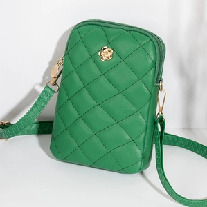 Detail of green quilted phone bag with golden camellia ornament and zipper closure