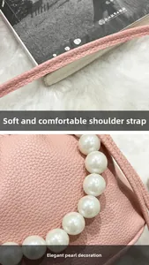 Detail shot of the pink lychee leather texture and the elegant pearl handle chain