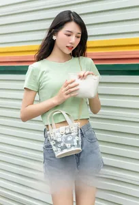 Gros plan du sac en PVC transparent à motif marguerites avec pochette et chaîne