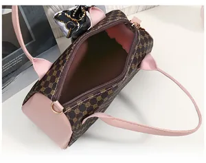 Vue détaillée du sac cylindre marron avec finitions en cuir rose et foulard en soie