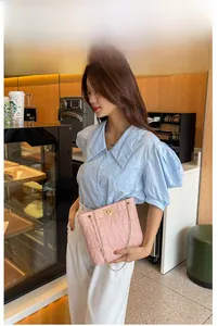 Detailed shot of pink quilted leather bag with elegant gold chain and turn-lock closure