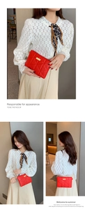 Detail view of red quilted leather mini crossbody bag with gold chain strap on a model
