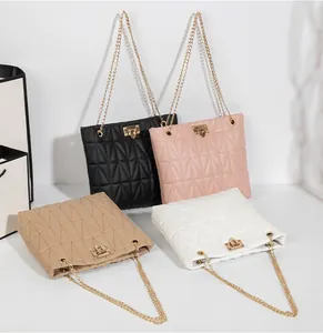 Detail of chevron quilted bucket bags in black, pink, and white with gold chain straps