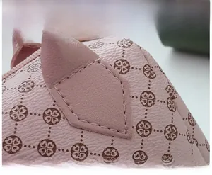 Macro detail of pink leather texture with clover floral patterns and fine stitching
