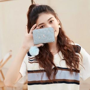 Portamonete in peluche azzurro con ricami floreali e dettagli trapuntati chic