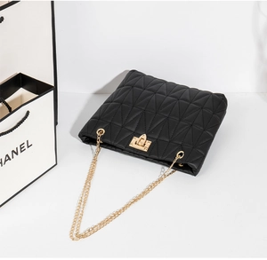 Detail of black quilted leather bucket bag with gold chain strap and twist lock closure