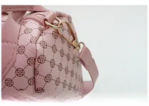 Detail of pink lychee textured leather bag with gold hardware and floral pattern