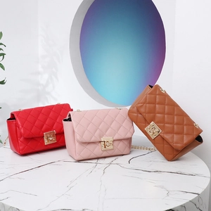 Borse trapuntate chic in rosso, rosa e marrone su tavolo di marmo con luci moderne