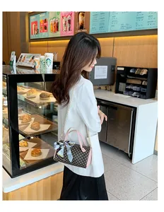 Vue détaillée du mini sac cylindre avec poignées roses et foulard en soie à motif