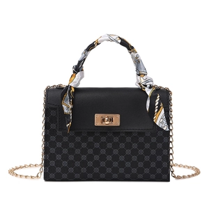 Classic black crossbody handbag with clover pattern, gold lock, and silk scarf handle