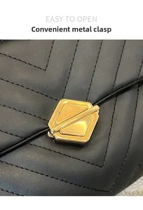 Close-up of elegant V-quilted black leather with a golden geometric swivel lock closure