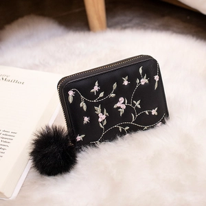 Portefeuille noir pour femme en similicuir avec broderies florales et pompon doux attaché