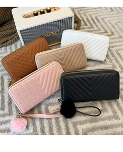 Collection of quilted long wallets with zipper and pompom charms in five neutral colors