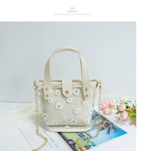 Détail du sac transparent en PVC à marguerites avec pochette beige et chaîne dorée