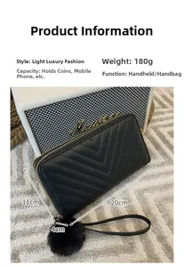 Detailed view of V-quilted long wallet with wristlet strap and plush pom-pom charm