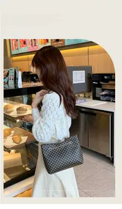 Detail of a brown pattern bucket bag with chain strap shown in a daily scene context