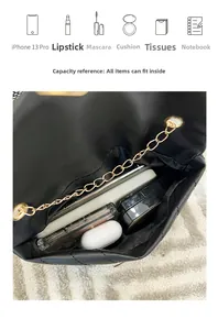 Internal capacity view of black quilted flap bag with chain strap and various accessories