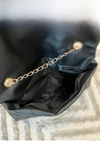 Detailed interior of a black quilted chain bag showcasing large storage capacity
