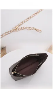 Detail view of the golden metal chain strap and brown monogrammed bucket bag interior