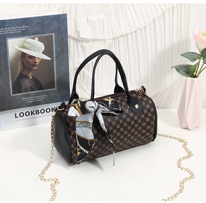Détail du sac Boston vintage avec motif monogramme, foulard en soie et chaîne dorée