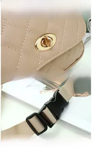 Détail du sac en PU matelassé beige avec fermoir doré poli et bandoulière en tissu à clip