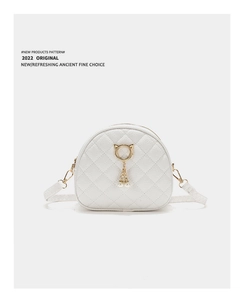 Detail of white quilted crossbody bag featuring cat-ear golden ring and pearl pendant