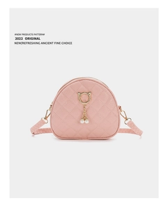 Detail of pink quilted leather bag with golden cat-ear ring and pearl tassel charm