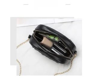 Détail du sac à bandoulière matelassé noir montrant sa grande capacité pour le maquillage