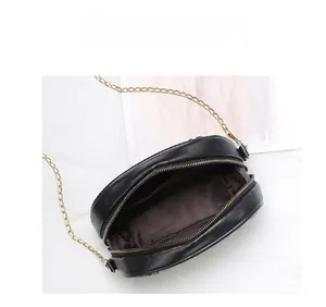 Détail de l'intérieur d'un mini sac en cuir noir avec sa bandoulière chaîne dorée
