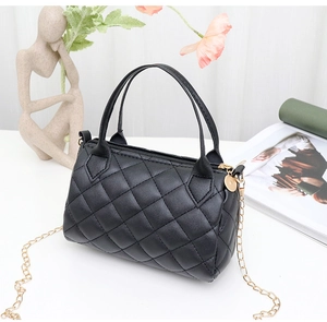 Détail du sac Boston matelassé noir avec surpiqûres en losange et bandoulière chaîne