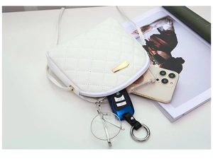 Borsa trapuntata bianca con dettagli dorati che mostra lo spazio per telefono e chiavi